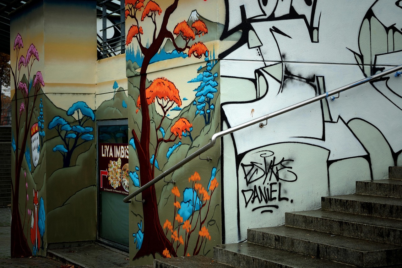 Mural de arte urbana com árvores e pássaros ao lado de uma escada.